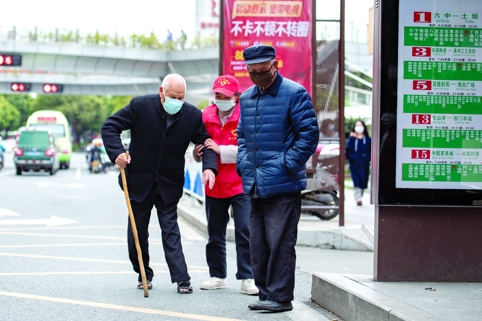 图为：3月5日，德化县大学生志愿者在南门公交站帮小朋友戴口罩。（许华.jpg