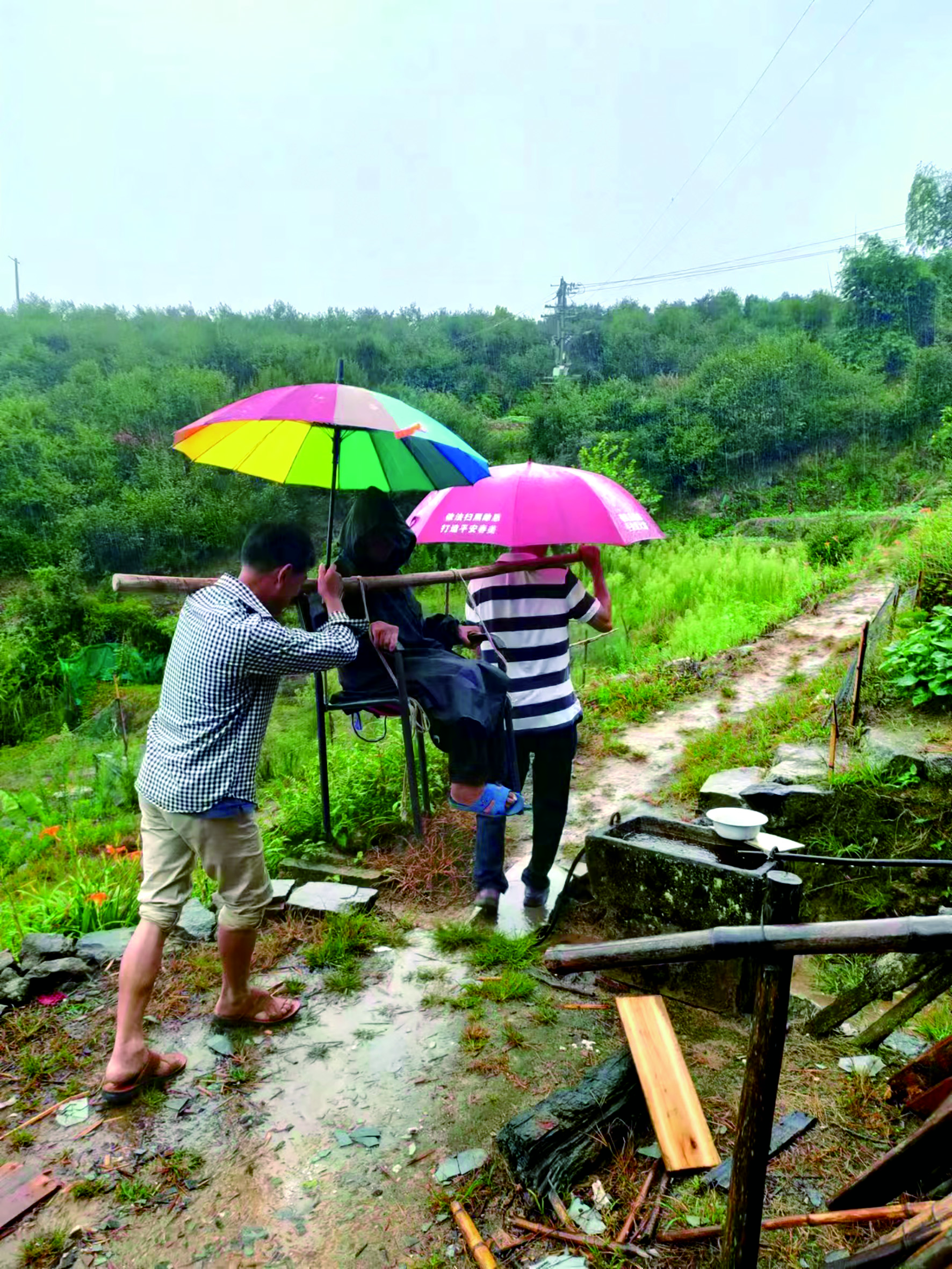 在春美乡新阁村，镇村干部现场利用椅子、棍子制作简易担架，协助瘫痪老人转移到避灾点.jpg